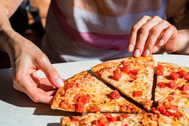 Halkların elleri domates ile taze pizza Margherita dilimleri alarak