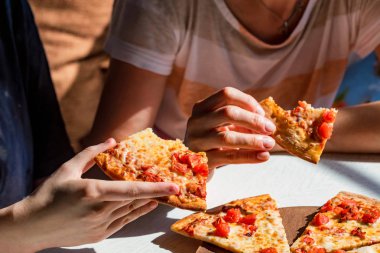 Halkların elleri domates ile taze pizza Margherita dilimleri alarak
