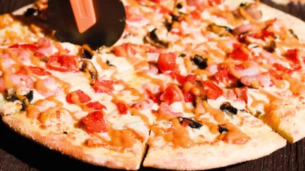 Uzavření osoby, která krájí pizzu s pepperony na více plátků — Stock video