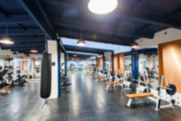 Suddig utsikt över modern gym inredning med maskiner och håls lagnings väska — Stockfoto