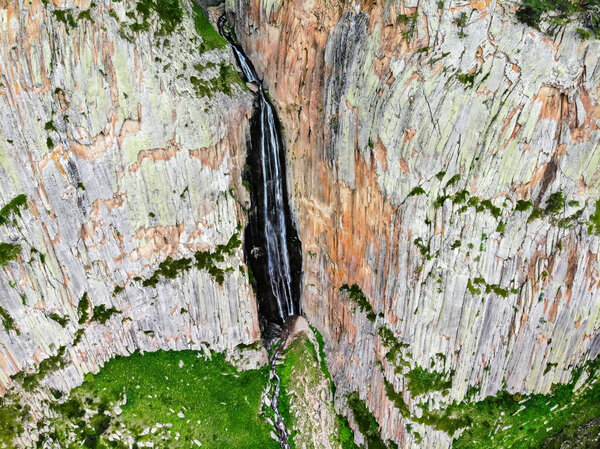 Summer landscape with mountain waterfall between two rocks taken by drone