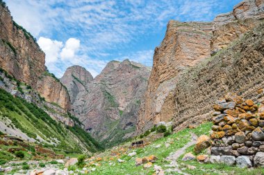 Dağların uzak görünümünde taş ve nehirden yapılmış küçük kırsal kulübe
