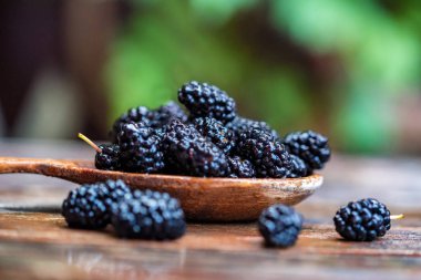 Masadaki tahta kaşıkla taze dut meyvesini kapat.