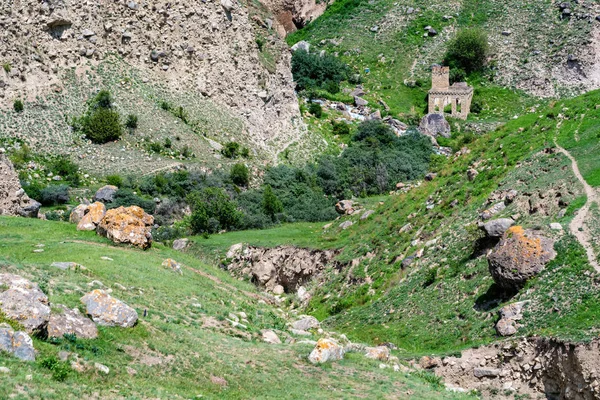 Ruinas de piedra. Vista lejana de la torre en las montañas de verano — Foto de Stock