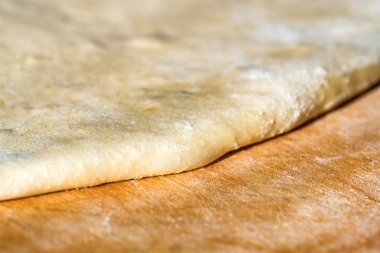 Ahşap tahta üzerinde beyaz çiğ hamur kapatın