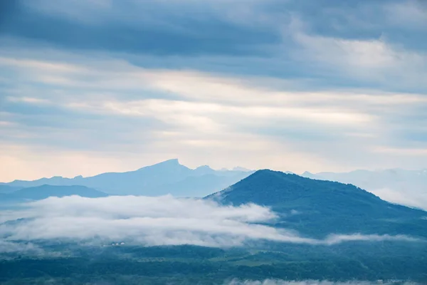 Scenic view of foggy mountains. Clouds and green mountain forest view