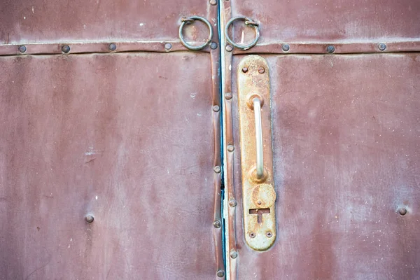 오래된 빨간 문과 녹슨 문 손잡이를 닫습니다. — 스톡 사진
