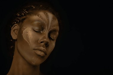 Yüzünde kabile resimleri olan Afrikalı bir kadının sanat fotoğrafı.