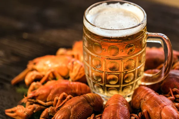 Boiled crayfish with beer on wooden background