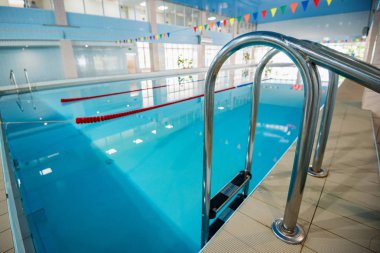 Metal merdivenli kapalı yüzme havuzu görünümü