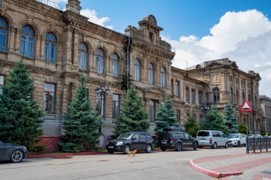 KERCH - 5 AĞUSTOS 2019: Kerch 'teki güzel antika binanın dış manzarası ve önünde park edilmiş arabalar. Kerch, Kırım 'ın en eski kentlerinden biri olarak kabul edilir.