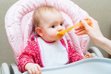 Ağzı açık beslenirken küçük kız bebek