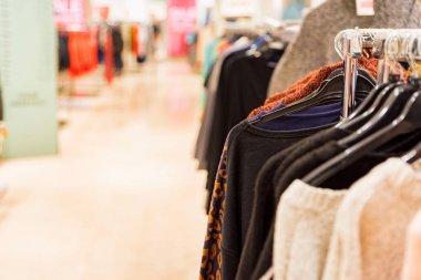 Kazak modern giyim mağazasında raylar üzerinde asmak