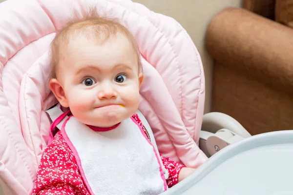 Lustiges kleines Mädchen, während es im Kinderwagen gefüttert wird — Stockfoto