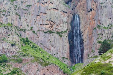 İki kayanın arasında dağ şelalesi olan yaz manzarası