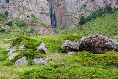 İki kayanın arasında dağ şelalesi olan yaz manzarası