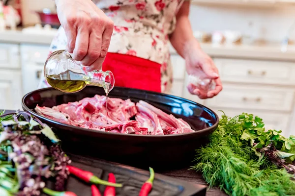 Cook adds oil to raw lamb ribs on frying pan close up — Stock Photo, Image
