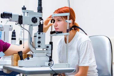 Kırmızı saçlı genç kız lazer göz pıhtılaşması alır