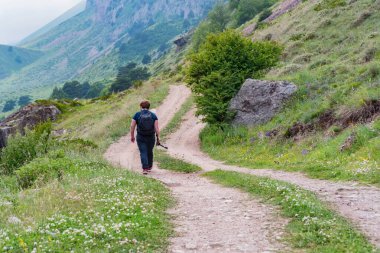 Arkadan bakan erkek yürüyüşçü Kuzey Kafkasya 'daki güzel dağlarda yürüyor
