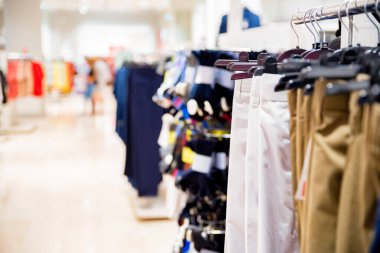 Modern giyim mağazasında pantolonlar raylara asılır.