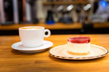 Arka planda bir fincan kahve olan vanilyalı kek. Kapuçino.