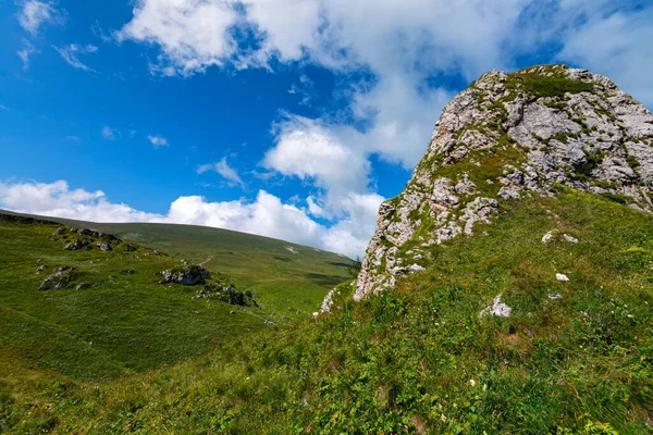 Hermoso prado de montaña con infinito cielo azul y nubes — Foto de Stock