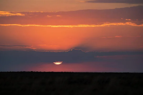 Dramatisk solnedgång himmel med mörka moln och röd sol — Stockfoto