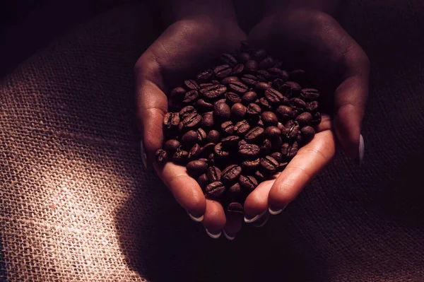 Close-up background of brown roasted coffee beans in hands — Stock Photo, Image