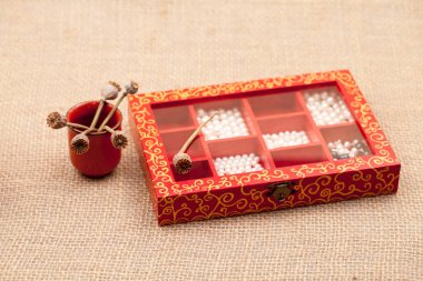 Bardakta bir kutu dolusu inci ve kurutulmuş haşhaşla natürmort