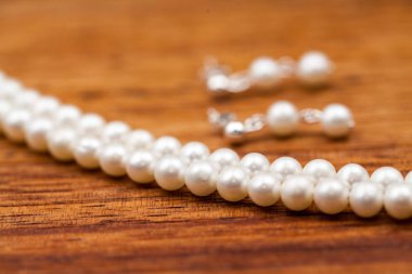 Bulanık ahşap arka plan üzerinde beyaz inci boncuklar