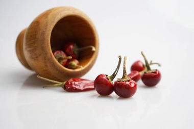 Beyaz arka plan üzerinde kırmızı kurutulmuş biber ile Ahşap harç