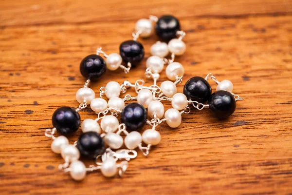 Perles Élégantes Noir Blanc Avec Chaîne Sur Fond Bois — Photo