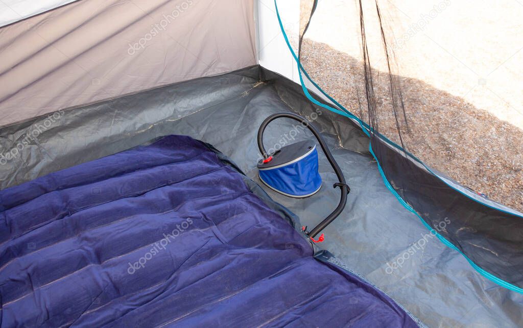 Pump for inflating a mattress in a tent outdoors.
