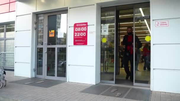 Un hombre con máscara protectora sale del supermercado con una botella de agua. La vida durante la pandemia del coronavirus. Medidas de protección y prevención. Esto es nuevo normal. Rusia, Volgodonsk junio 25, 2020 . — Vídeos de Stock