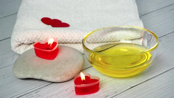 Le concept d'un Spa pour la Saint-Valentin. Une esthéticienne verse de l'huile de massage dans un bol. Préparation du bureau des cosmétologues pour les séances de relaxation et de bien-être. Procédure de bain, cosmétologie — Video