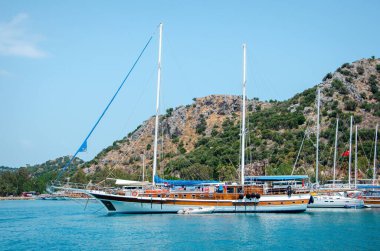 Akdeniz 'deki güzel bir yaz manzarasının arka planında turist gemisi. Türkiye 'ye gezi. Mimarinin tarihi anıtının deniz turu. Tatildeki insanlar.