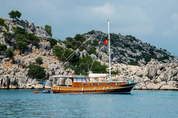 Tourist ship on the background of a beautiful summer mountain landscape on the Mediterranean sea. Excursion to Turkey. Sea tour of the historical monument of architecture. People on vacation.