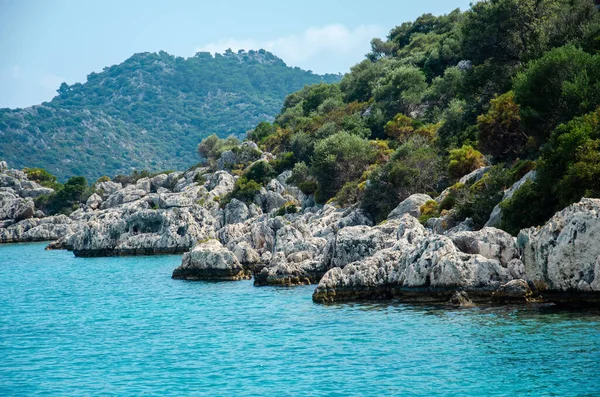 Seascape. 물에서부터 지중해에 있는 섬 들에 이르기까지 전경을 바라본다. 터키의 자연 그대로의 야생. 돌 절벽과 산들이 푸른 관목들과 나무들로 뒤덮여 있습니다. 즐거움을 주는 배의 여름 풍경. — 스톡 사진