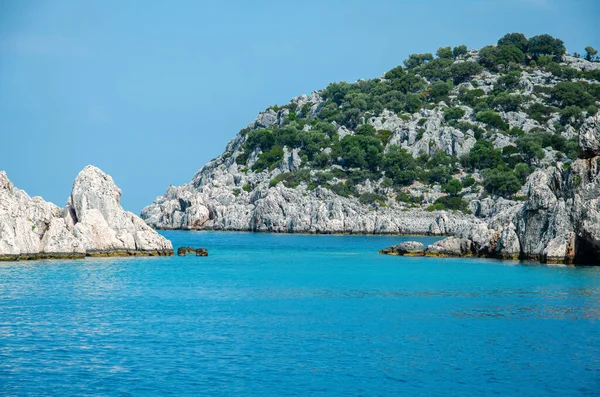 Seascape. 물에서부터 지중해에 있는 섬 들에 이르기까지 전경을 바라본다. 터키의 자연 그대로의 야생. 돌 절벽과 산들이 푸른 관목들과 나무들로 뒤덮여 있습니다. 즐거움을 주는 배의 여름 풍경. — 스톡 사진