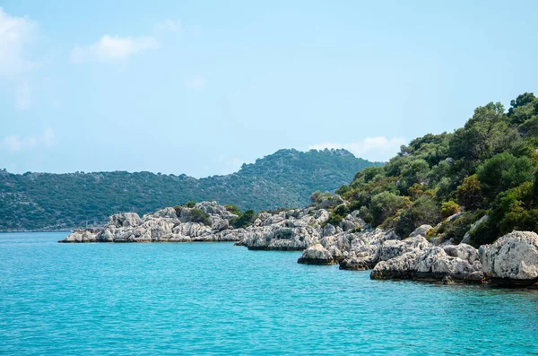 Seascape. Pohled z vody na ostrovy ve Středozemním moři. Nezkažená příroda Turecka. Kamenné útesy a hory pokryté zelenými keři a stromy. Letní krajina z rekreační lodi. — Stock fotografie