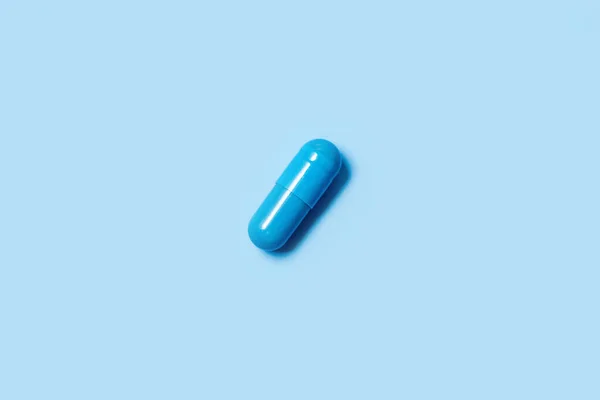 One blue capsule. Pills for mens health and sexual energy on an isolated background. Concept of erection, potency. Treatment of male infertility and impotence. Copy space. — Stock Photo, Image