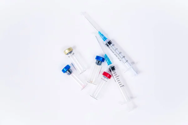 Veterinární a lékařské skleněné injekční lahvičky a dvě injekční stříkačky pro očkování na bílém izolovaném pozadí. Tekuté léky nebo vakcíny k léčbě lidí a zvířat proti virům, nemocem, chřipce, vzteklině. Kopírovat mezeru — Stock fotografie