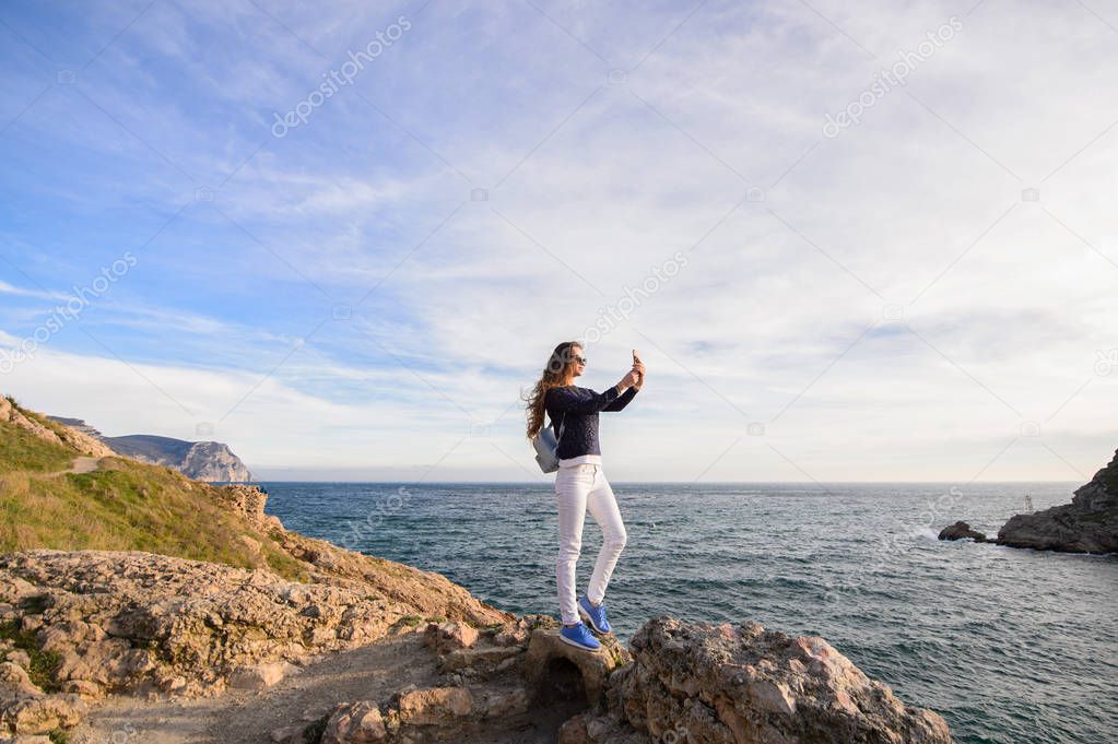 The girl with long hair photographes itself near the sea