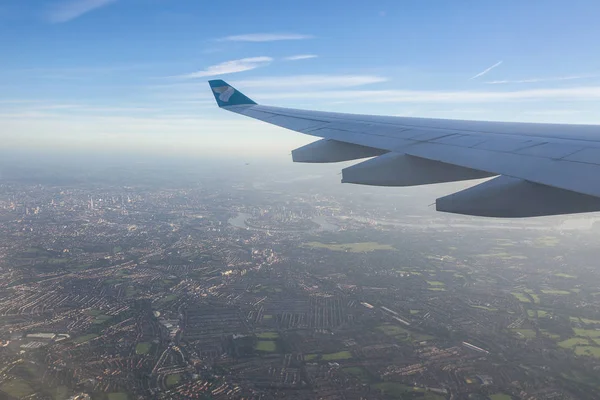 상업용 비행기에서 내려다보는 흰 구름 과푸른 하늘 과 새의 눈으로 바라본 도시. — 스톡 사진