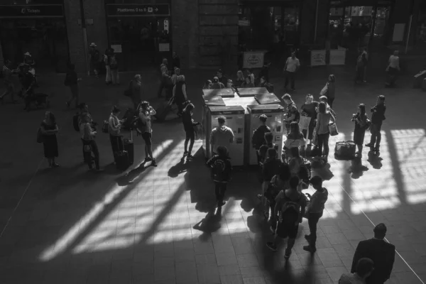 Svart och vit bild av människor som köper tågbiljett på tåget vid King 's Cross järnvägsstation, London, England. — Stockfoto