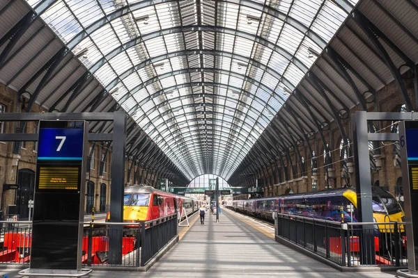 Ludzie podróżujący przez pociągi na platformach w King's Cross Station, Londyn, Anglia. — Zdjęcie stockowe