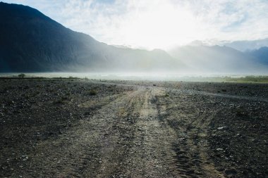 Hindistan 'ın Nubra Vadisi' nde, Leh Ladakh 'ta gündoğumu arka planında çarpıcı bir ışık ve güzel bir sis var. Lens alevli ışık manzarası.