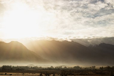 Hindistan 'ın Nubra Vadisi' nde, Leh Ladakh 'ta gündoğumu arka planında çarpıcı bir ışık ve güzel bir sis var. Lens alevli ışık manzarası.