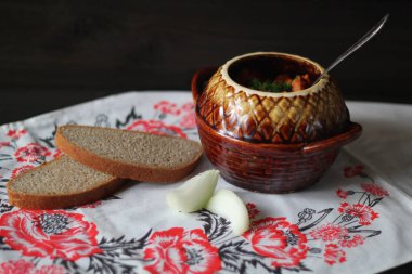 Patates, havuç ve ahşap zemin üzerine seramik tencerede baharatlar ile sığır eti Komposto