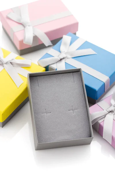 Small colorful paper gift boxes with bows for jewelry on white background